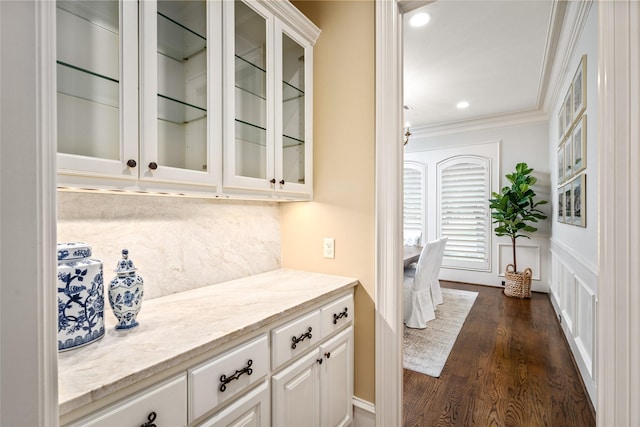 bar with dark wood finished floors, decorative backsplash, recessed lighting, and crown molding