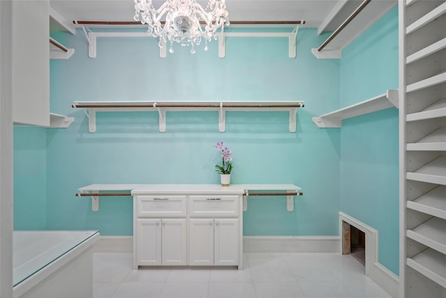 spacious closet with light tile patterned floors and a notable chandelier