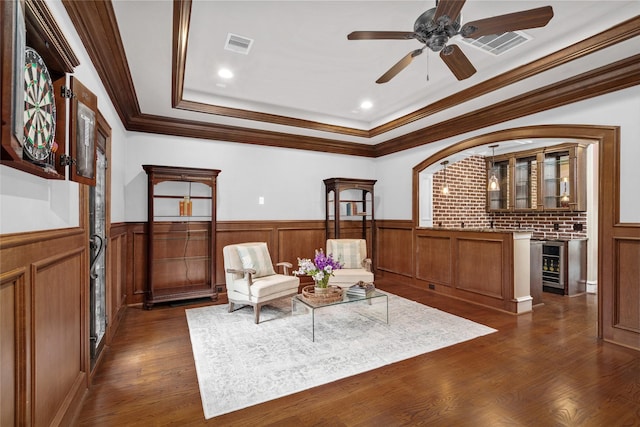 sitting room with beverage cooler, visible vents, and wainscoting