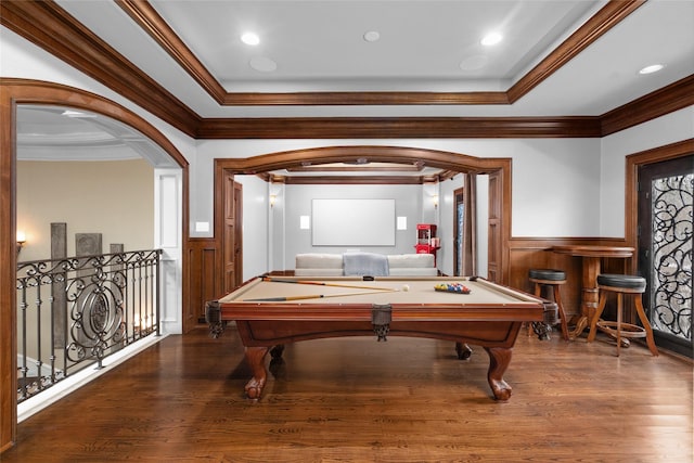 recreation room with arched walkways, wood finished floors, wainscoting, and crown molding