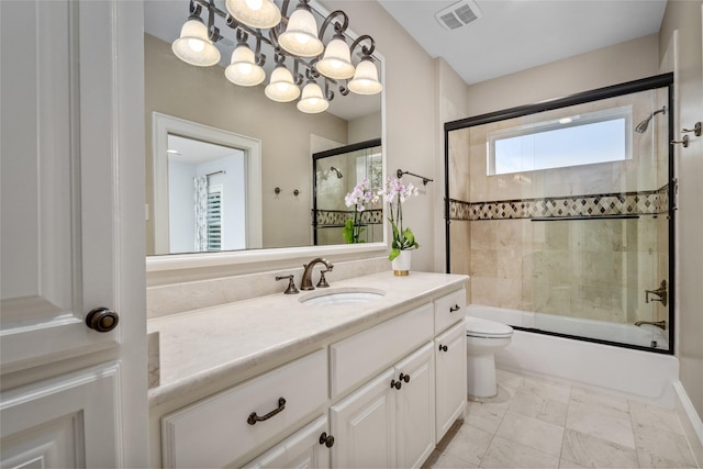 bathroom with vanity, toilet, visible vents, and bath / shower combo with glass door