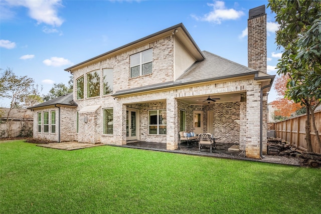 back of house with a patio, fence, a yard, a chimney, and brick siding