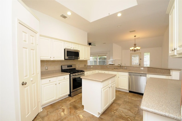 kitchen featuring stainless steel appliances, visible vents, backsplash, a sink, and a peninsula