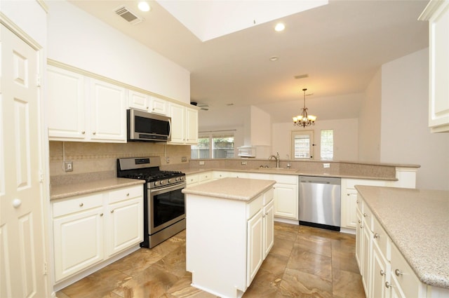 kitchen with a center island, decorative backsplash, appliances with stainless steel finishes, a sink, and a peninsula