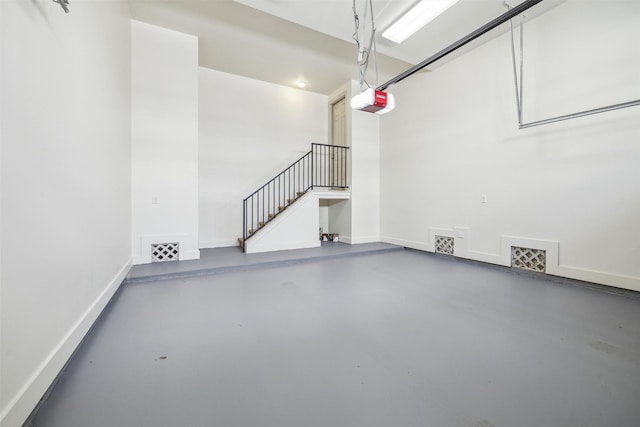 garage with visible vents, baseboards, and a garage door opener