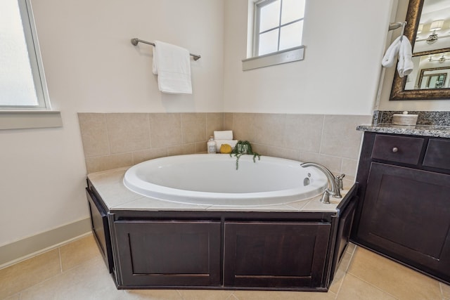 bathroom featuring a bath, vanity, and tile patterned flooring