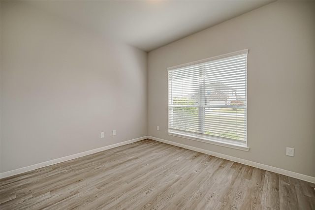 empty room featuring baseboards and light wood finished floors