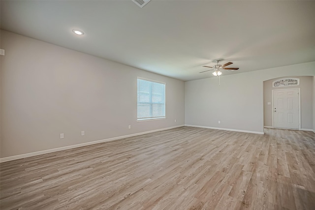 unfurnished room featuring light wood-type flooring, a ceiling fan, and baseboards