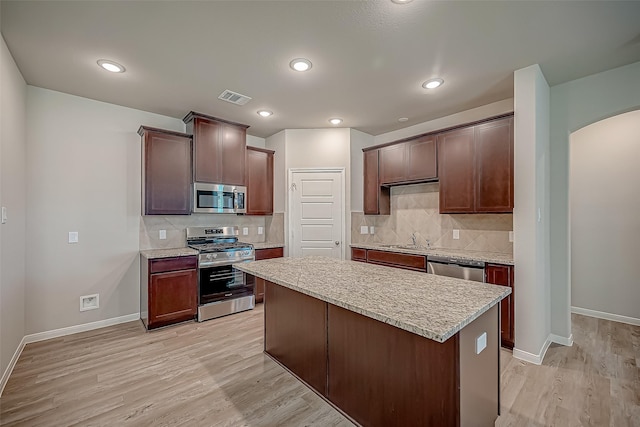 kitchen featuring stainless steel appliances, light wood-type flooring, light countertops, and visible vents