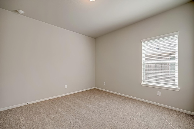 unfurnished room with carpet and baseboards