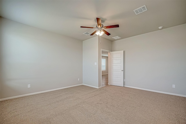 carpeted spare room featuring baseboards, visible vents, and a ceiling fan