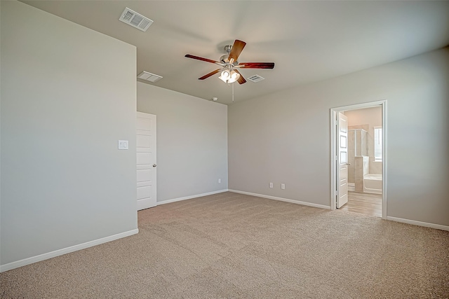 empty room featuring baseboards, visible vents, and light colored carpet