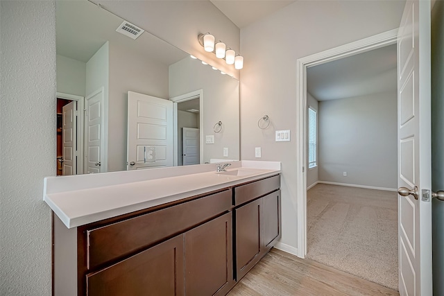 bathroom with baseboards, visible vents, wood finished floors, and vanity