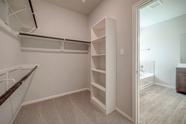 spacious closet featuring light wood-type flooring and visible vents