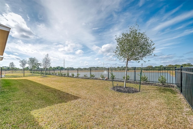 view of yard with a water view and a fenced backyard