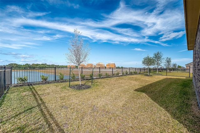 view of yard with a water view and a fenced backyard