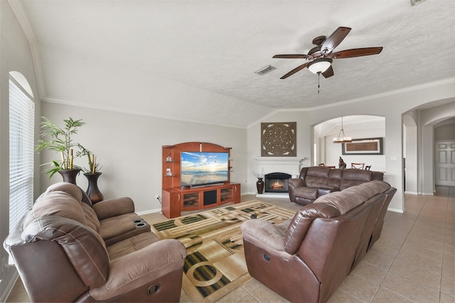 living area featuring ornamental molding, arched walkways, visible vents, and vaulted ceiling