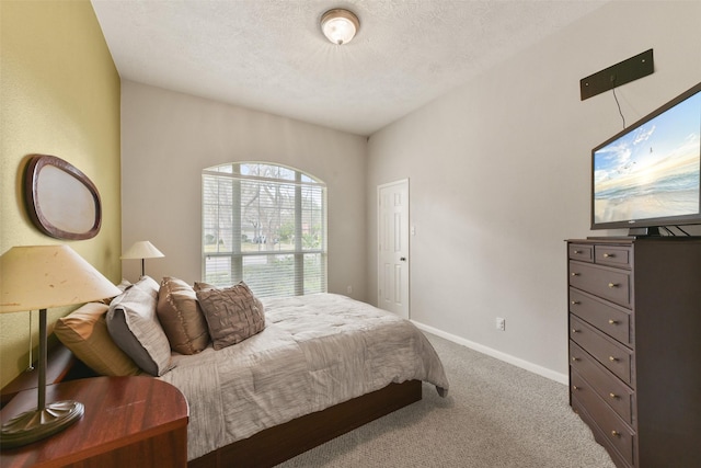 carpeted bedroom with a textured ceiling and baseboards