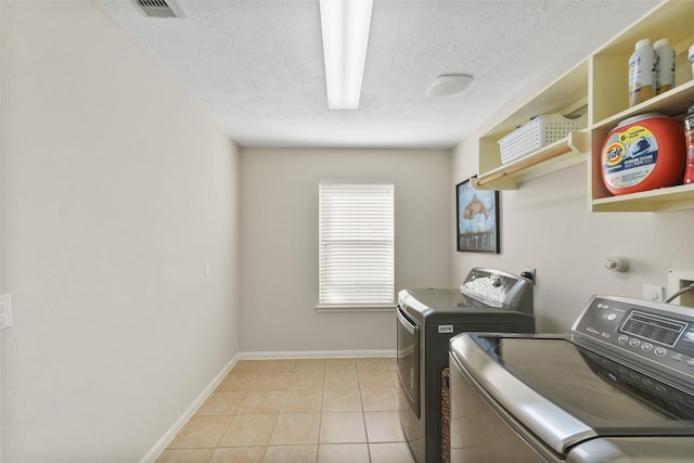 laundry room with laundry area, light tile patterned floors, visible vents, baseboards, and washer and dryer