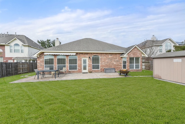 rear view of property with a fenced backyard, a chimney, a patio, and brick siding