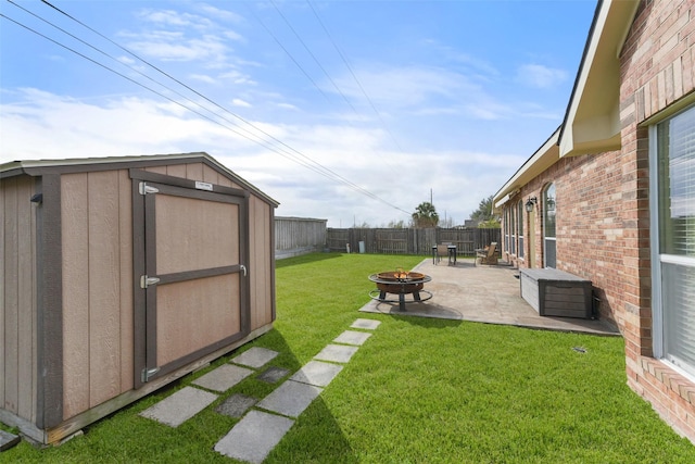 view of yard featuring a storage shed, an outdoor fire pit, a fenced backyard, an outdoor structure, and a patio area