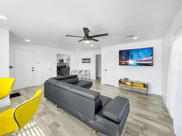 living room with ceiling fan, recessed lighting, and light wood-style floors