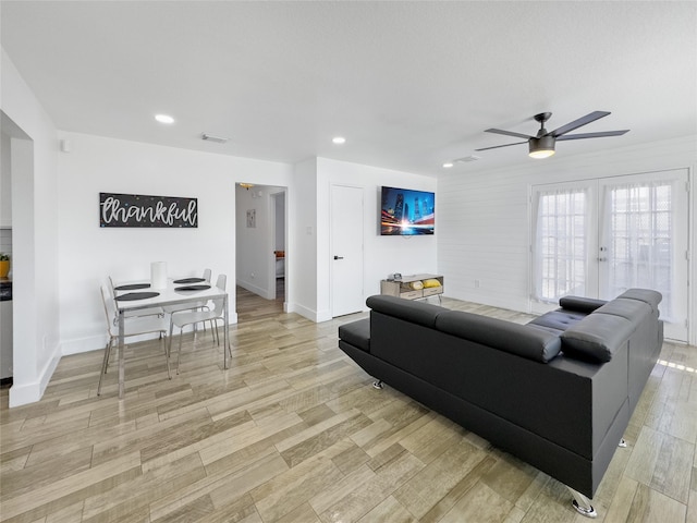 living area featuring recessed lighting, french doors, light wood-style flooring, and baseboards