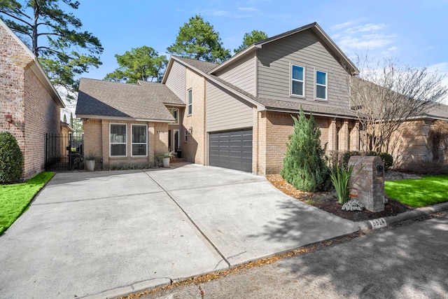 traditional-style house featuring a garage, driveway, brick siding, and a shingled roof