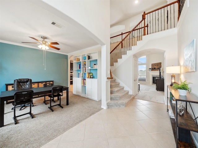 office space with light carpet, arched walkways, and crown molding