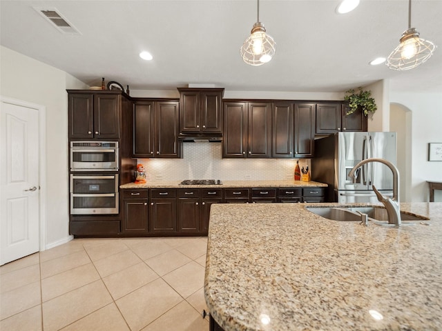 kitchen featuring hanging light fixtures, dark brown cabinetry, visible vents, and stainless steel appliances