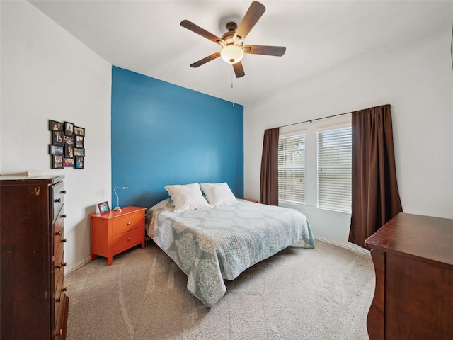 carpeted bedroom with ceiling fan and baseboards