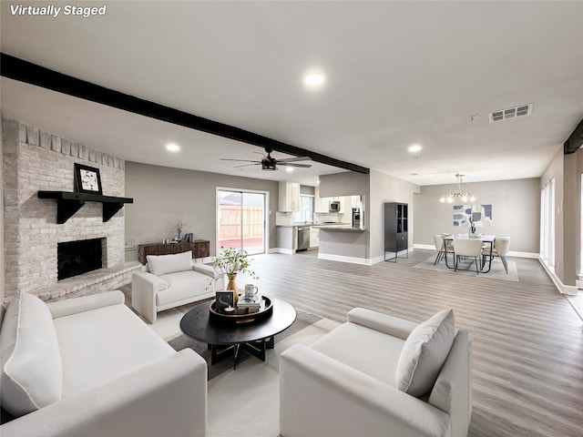 living room with baseboards, visible vents, a fireplace, beam ceiling, and recessed lighting