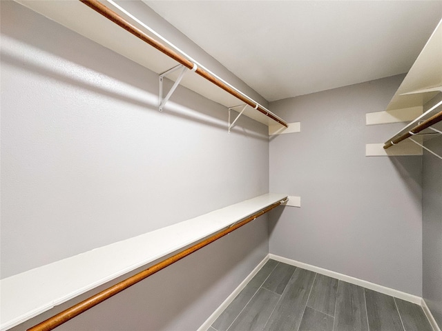 spacious closet with dark wood-style floors