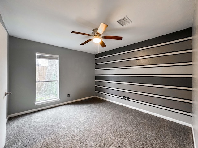 unfurnished room with carpet floors, a ceiling fan, visible vents, and baseboards