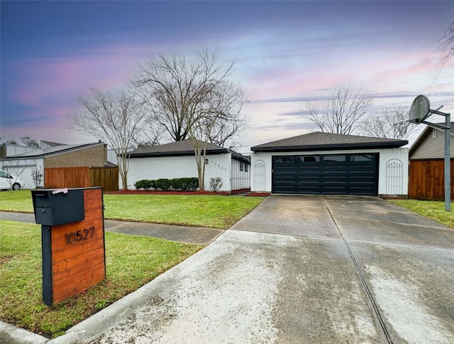 view of front of property with a yard, roof with shingles, fence, and a garage