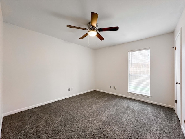 spare room featuring baseboards, dark carpet, and ceiling fan