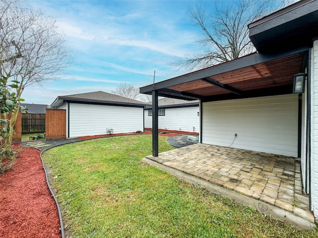 view of yard featuring an outbuilding, a patio, and fence