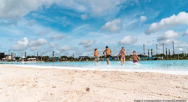 view of swimming pool with a water view and a view of the beach