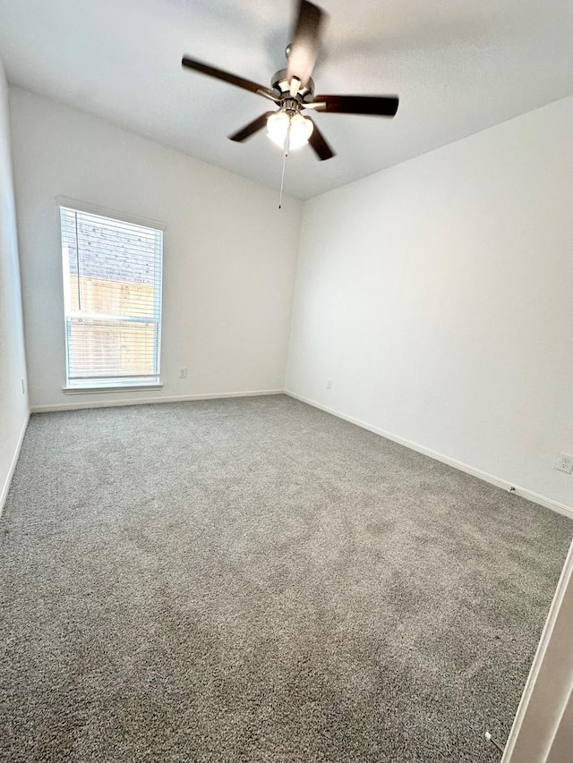 carpeted empty room with ceiling fan and baseboards