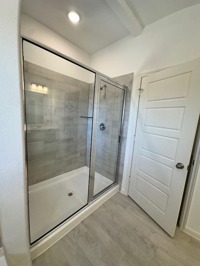 full bathroom featuring a shower stall and wood finished floors