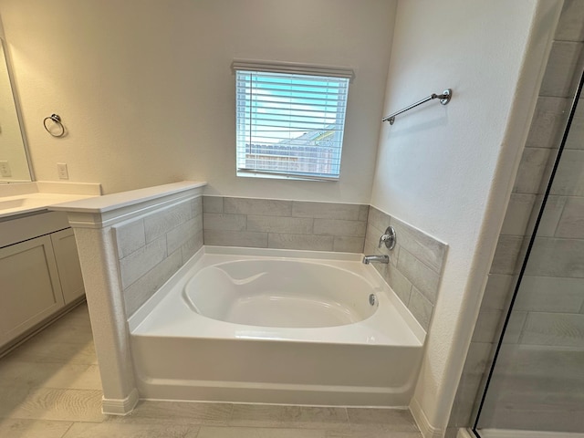 full bathroom featuring tiled shower, a garden tub, and vanity