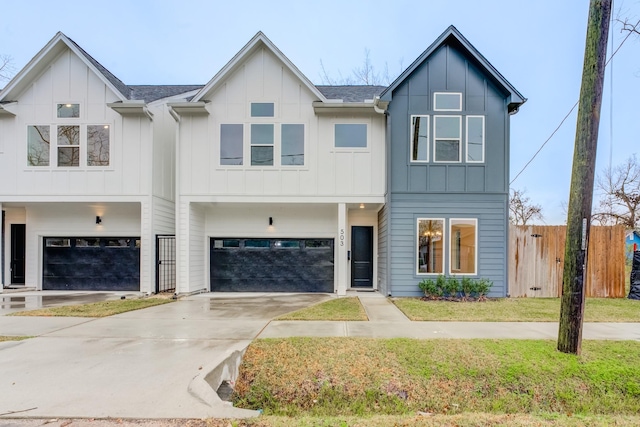 view of front of property featuring a garage, driveway, a front lawn, and board and batten siding