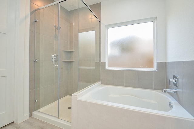 full bathroom featuring a garden tub and a shower stall