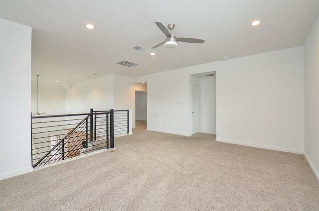 spare room with light colored carpet, visible vents, baseboards, and recessed lighting