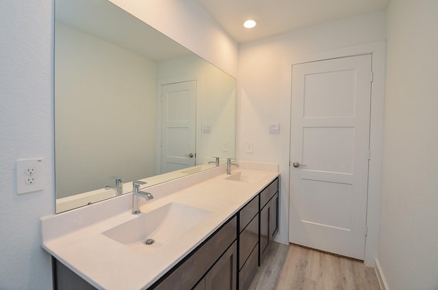 full bath with wood finished floors, a sink, and double vanity