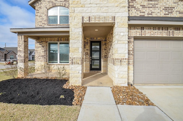 entrance to property with a garage, stone siding, and brick siding