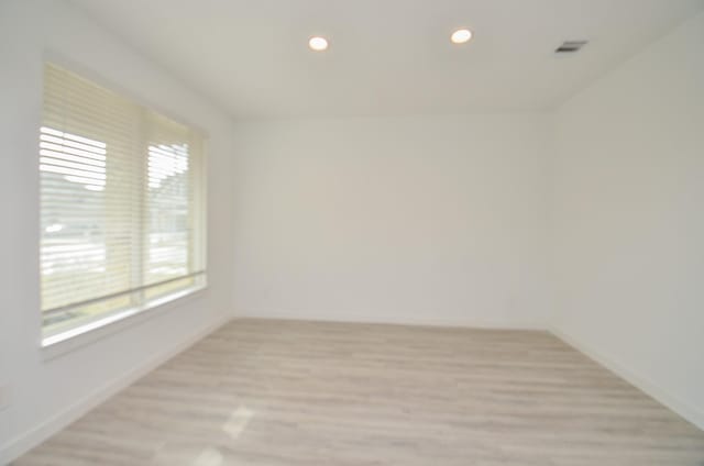 spare room with recessed lighting, visible vents, light wood-style flooring, and baseboards