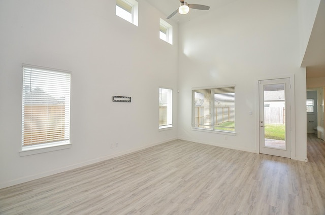 unfurnished living room featuring light wood finished floors, ceiling fan, and baseboards