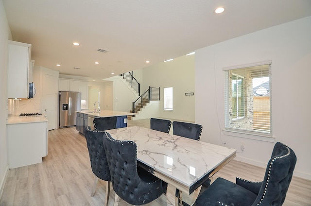 dining room with recessed lighting, visible vents, baseboards, light wood-style floors, and stairway