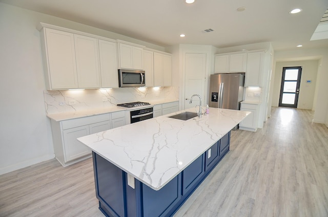 kitchen with stainless steel appliances, white cabinetry, and a sink